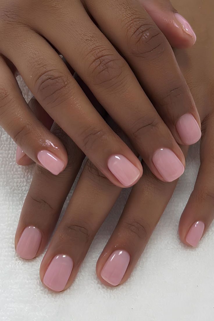Manicure semipermanente en tono rosa sobre piel morena